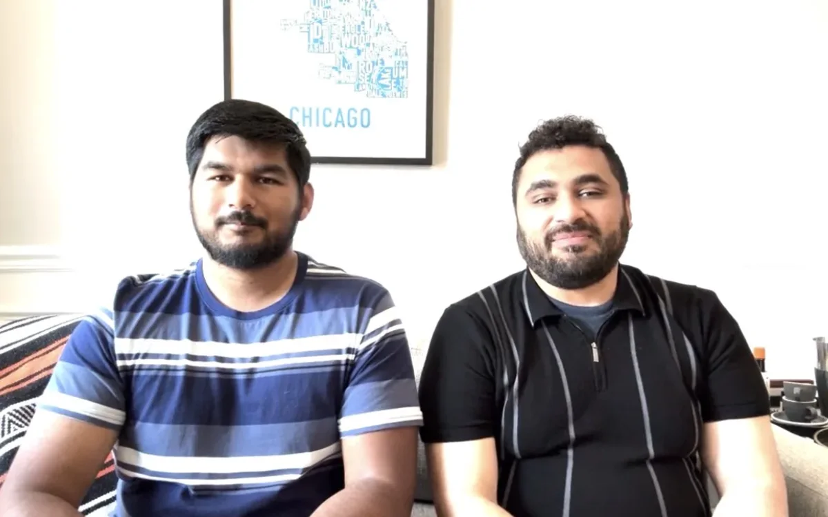 Khaleel Rahman and Dr. Muhammad Abubakar sitting side by side on a sofa in front of a framed Chicago print.