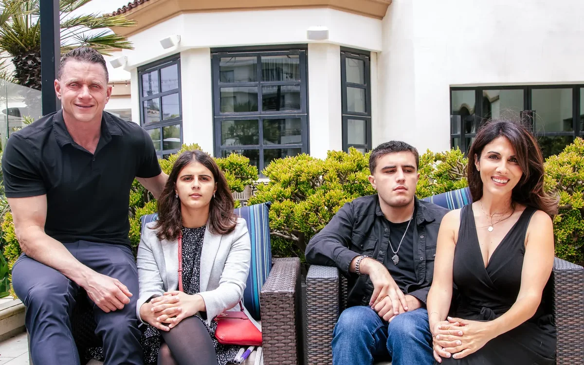 Bart, Mina, Brennan and Parisa sitting together outdoors on patio furniture.