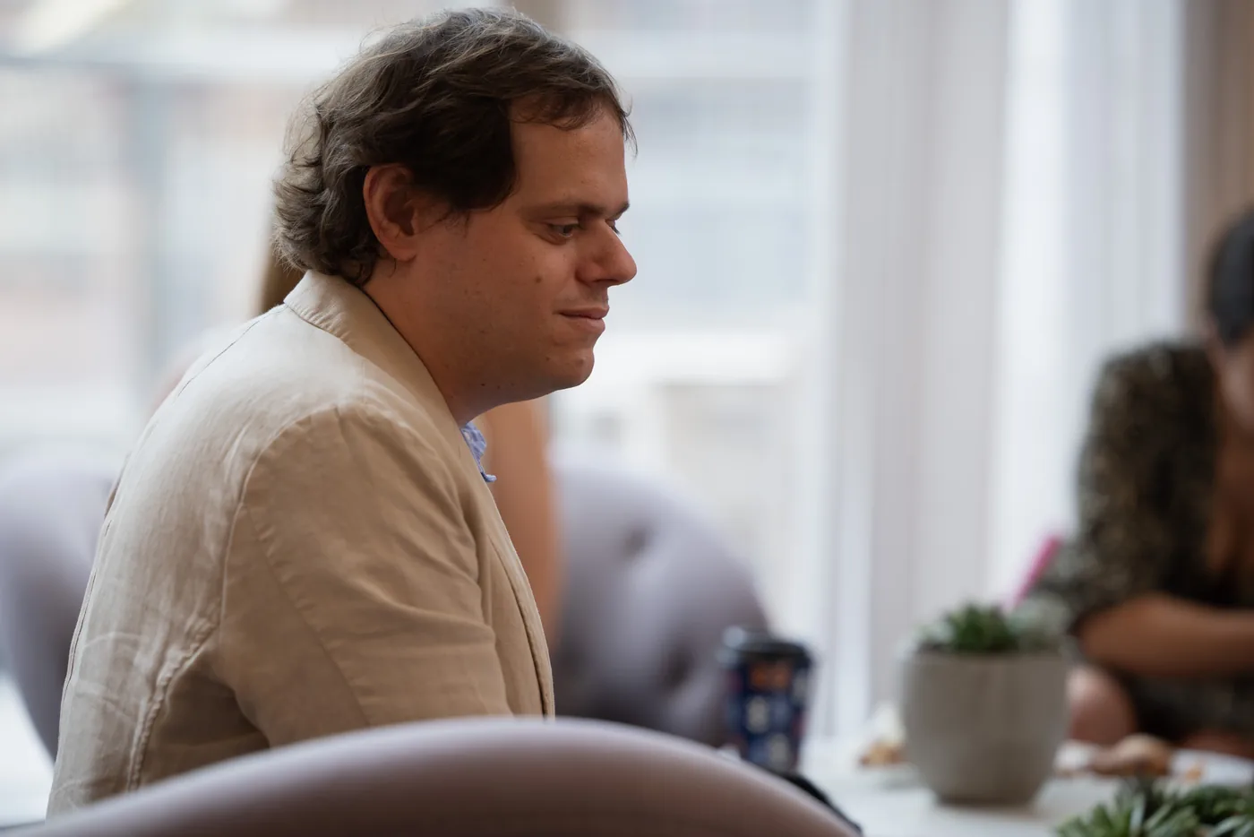 Ignasi Cambra, in a tan linen jacket, seated in profile beside a bright window.