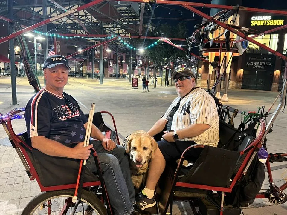 Ed and Brian in a rickshaw with Wesley in the middle.