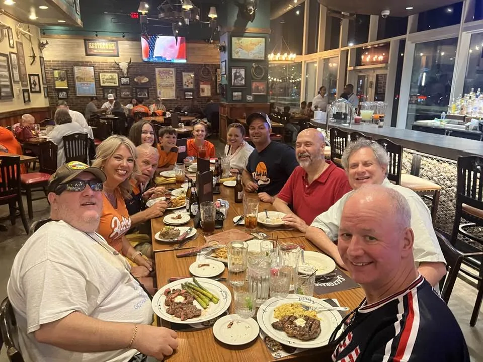 Brian, Ed, and David are having dinner. They are at a long table with 8 other people.
