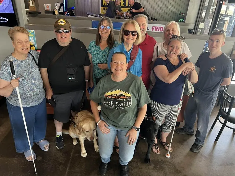 A group of people meet up at Old Town Tavern in Arvada, Colorado, with Brian's guide dog Wesley.
