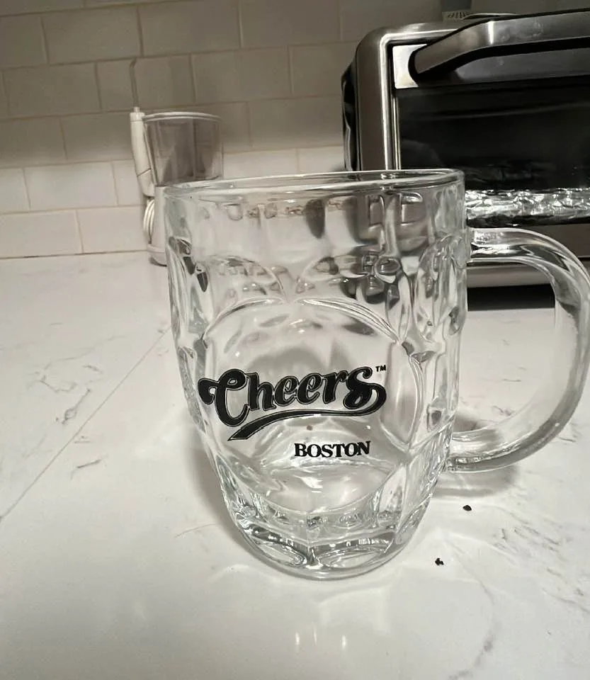 Empty glass mug with the Cheers logo on it.