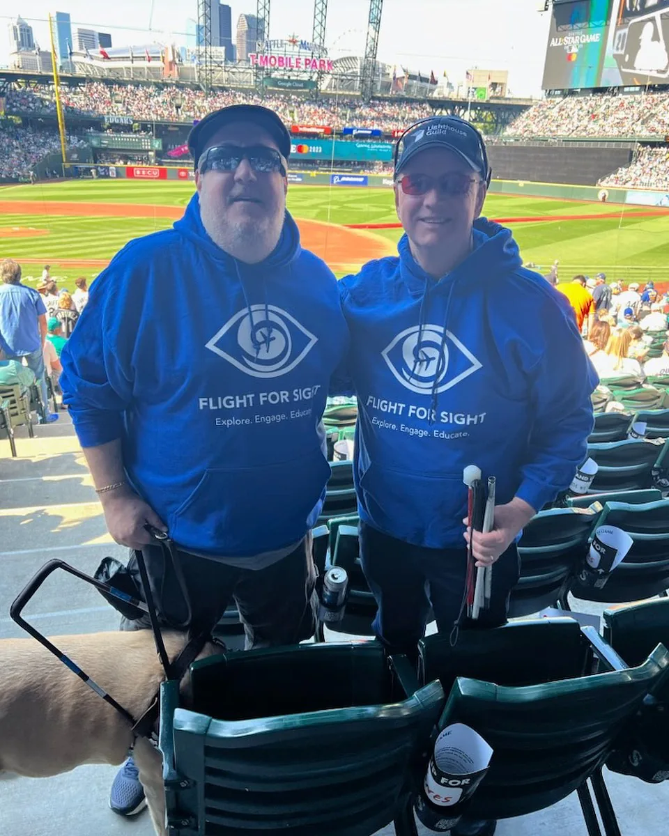 Brian and his guide dog Wesley with Ed at the MLB All-Star game, in Blind Travel Foundation sweatshirts.