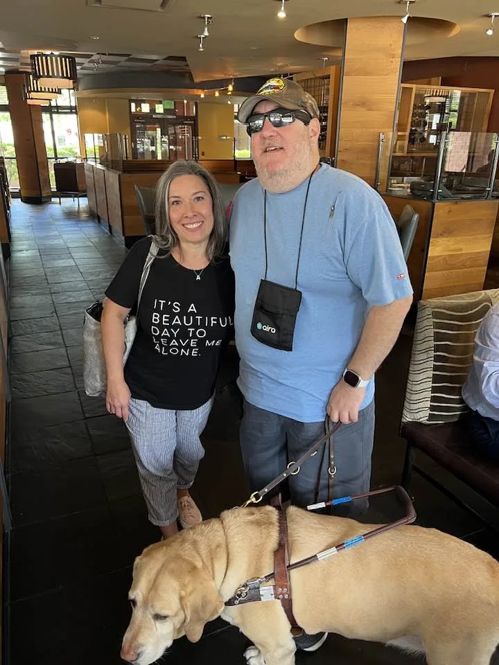 Brian and his guide dog Wesley with Alex in a restaurant.