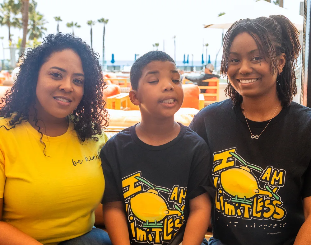 Three people outdoors wearing Team Limitless shirts.